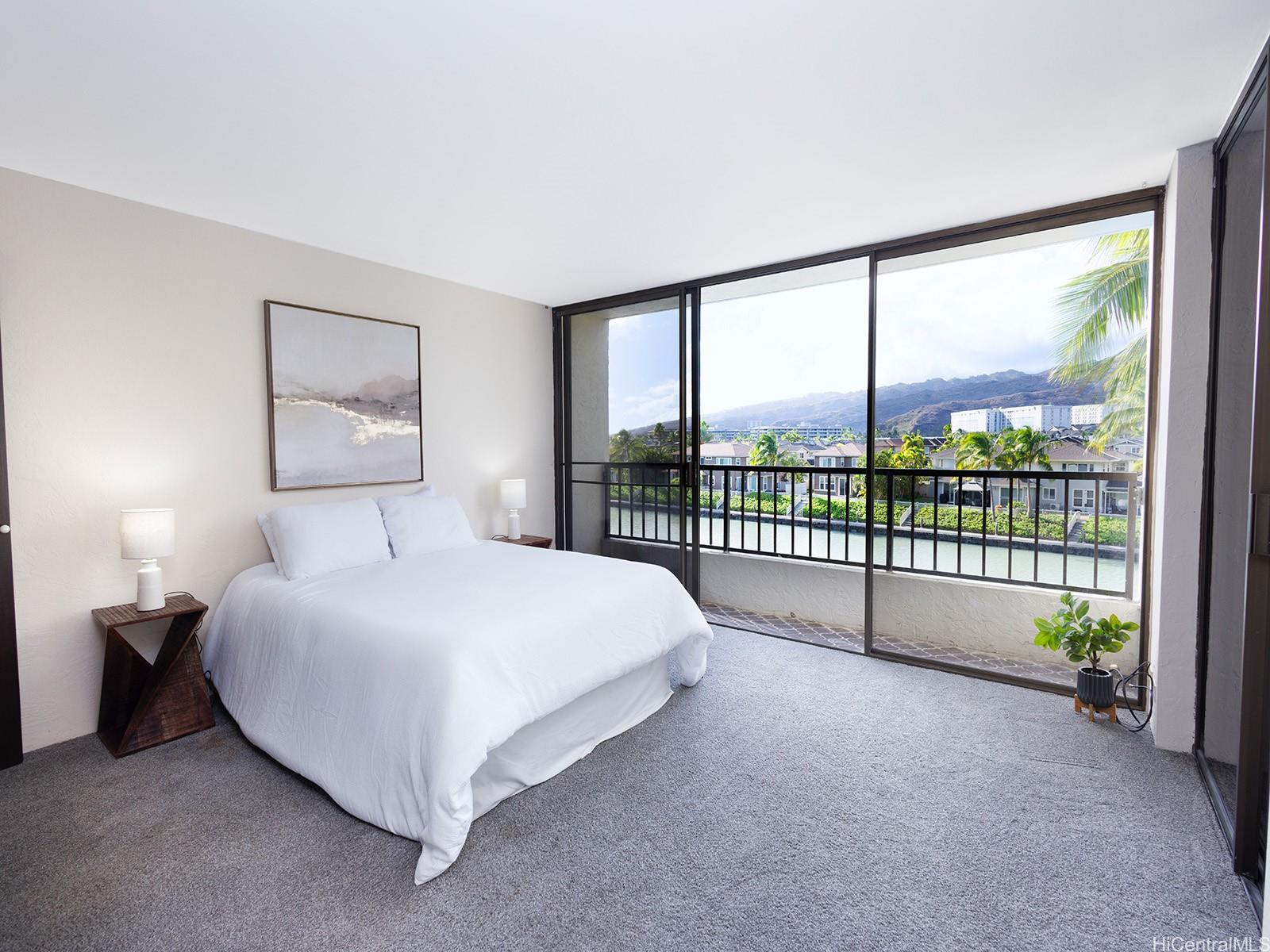 500 Lunalilo Home Road, Unit 13B Honolulu, HI 96825 - Photo 8 of 17 a large white bed sitting in a bedroom next to a window