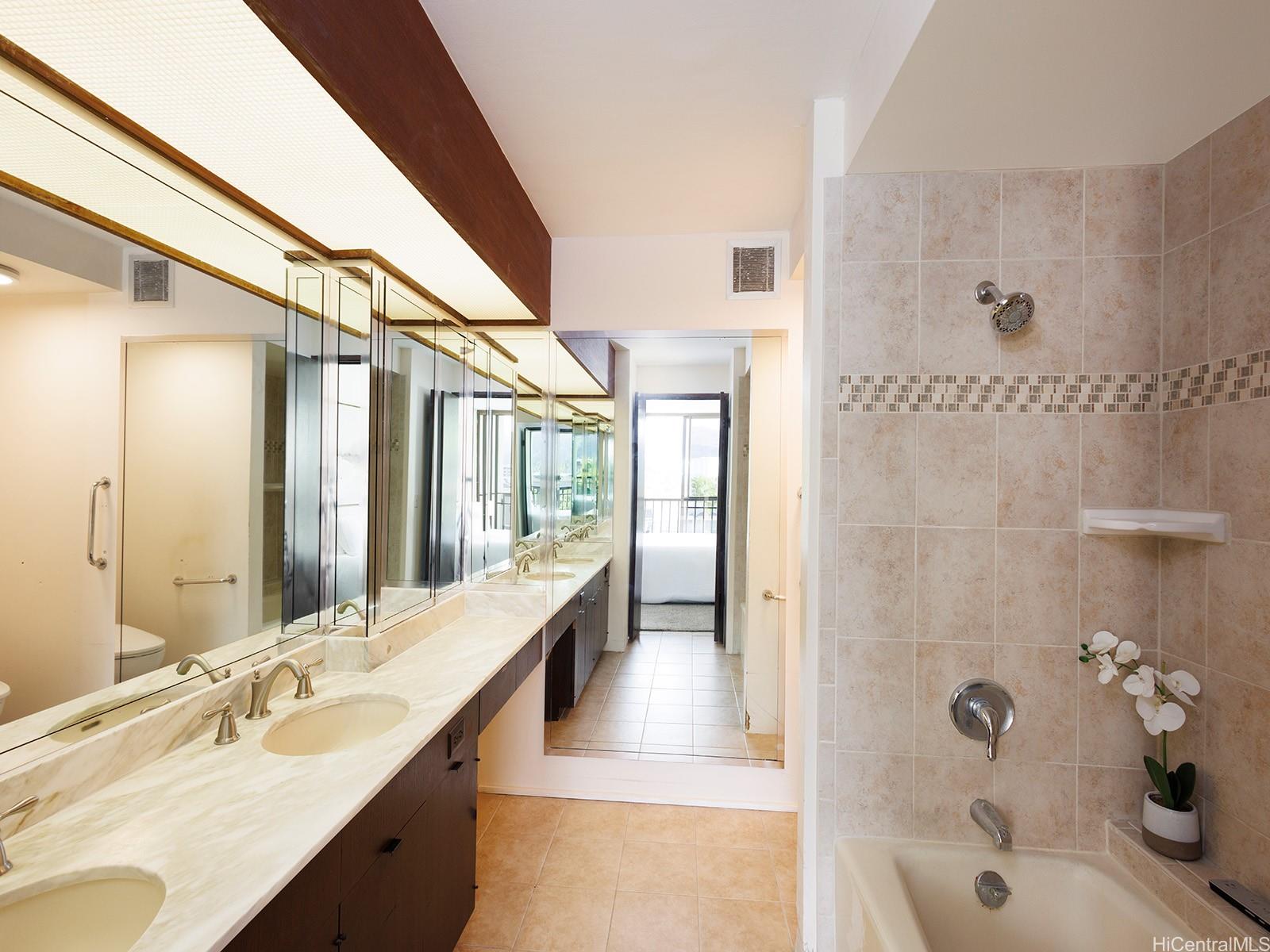 500 Lunalilo Home Road, Unit 13B Honolulu, HI 96825 - Photo 10 of 17 a bathroom with a tub sink shower and mirror