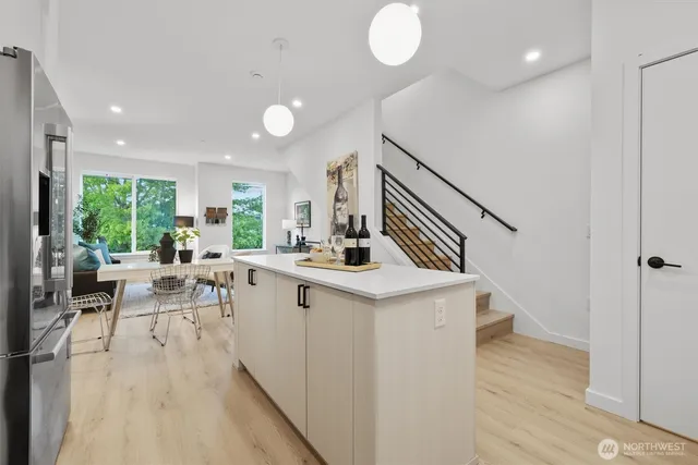 a kitchen with stainless steel appliances a refrigerator a stove a sink and white cabinets