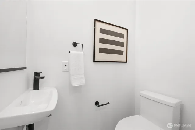 a bathroom with a sink a toilet and mirror