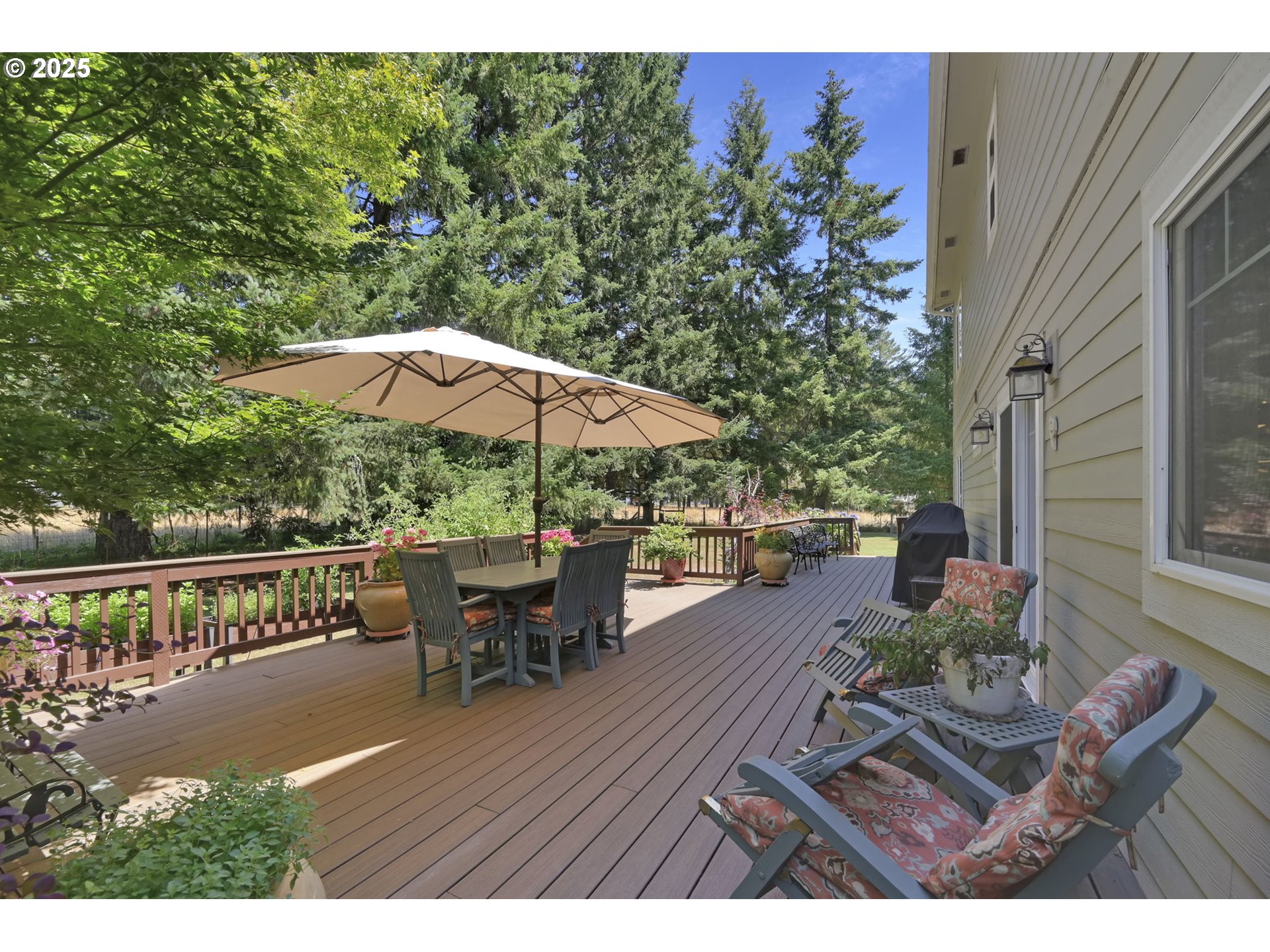 23859 Suttle Road Veneta, OR 97487 - Photo 30 of 46 a view of a patio with couches table and chairs under an umbrella with wooden floor