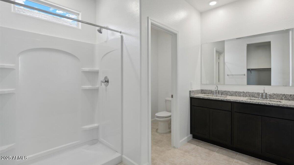 2019 West Solstice Avenue Apache Junction, AZ 85120 - Photo 15 of 17 a bathroom with a granite countertop sink toilet and shower