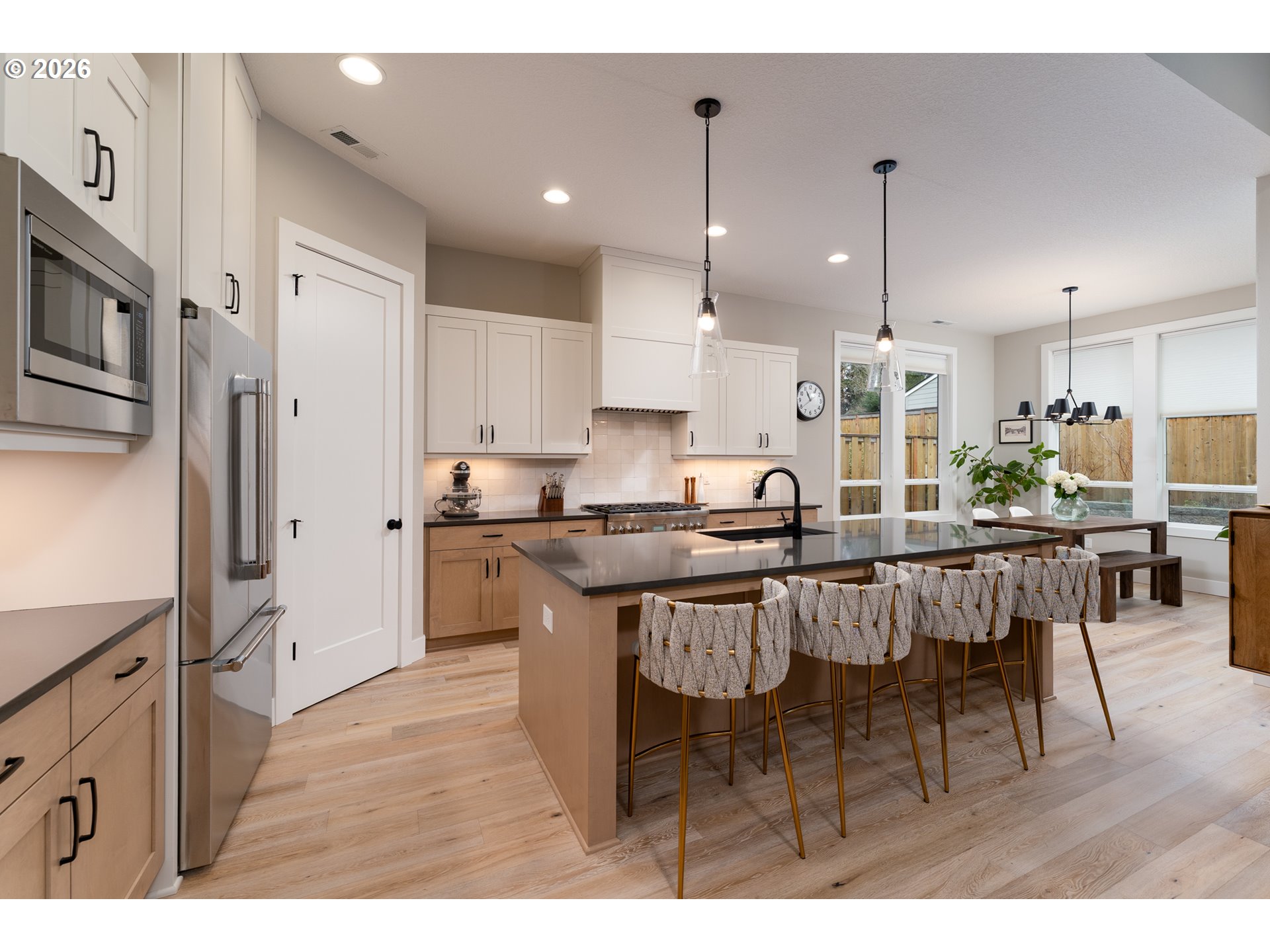 8044 Southwest Knudsen Place Portland, OR 97223 - Photo 17 of 46 a kitchen with stainless steel appliances kitchen island granite countertop a refrigerator a stove a sink a dining table and chairs with wooden floor