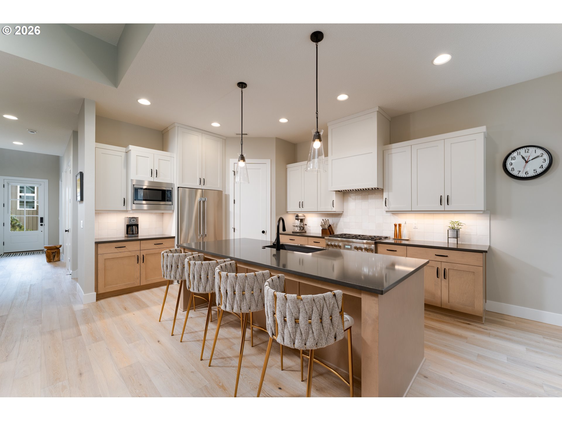 8044 Southwest Knudsen Place Portland, OR 97223 - Photo 18 of 46 a kitchen with stainless steel appliances granite countertop a stove top oven a refrigerator a sink and white cabinets with wooden floor