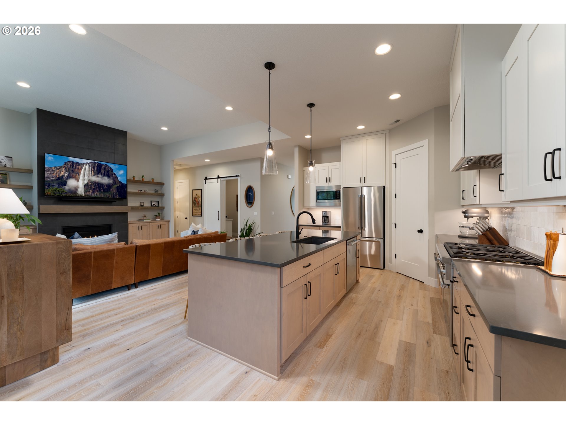 8044 Southwest Knudsen Place Portland, OR 97223 - Photo 21 of 46 a kitchen with stainless steel appliances kitchen island granite countertop a stove top oven a sink a refrigerator and white cabinets with wooden floor