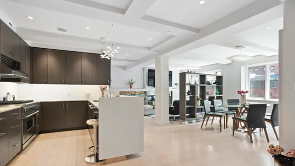 a living room with stainless steel appliances kitchen island granite countertop furniture and a flat screen tv
