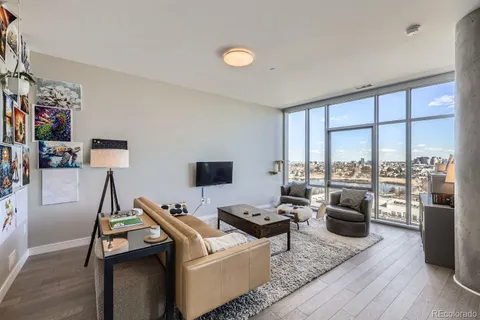 a living room with furniture a flat screen tv and a large window