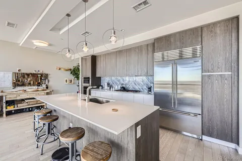 a kitchen with a sink a stove and chairs