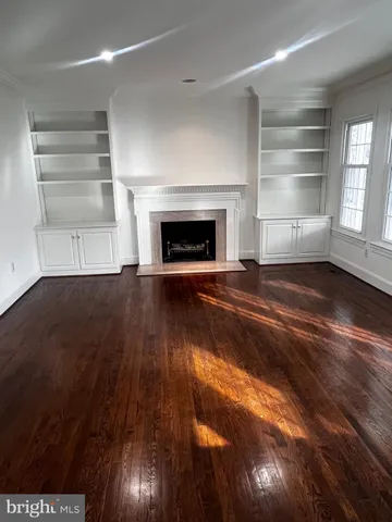 a view of an empty room with a fireplace and a window