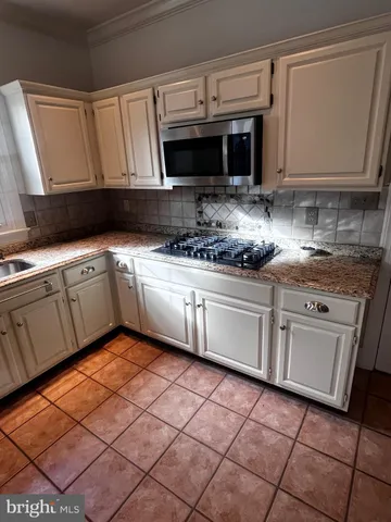 a kitchen with stainless steel appliances granite countertop a sink and a stove