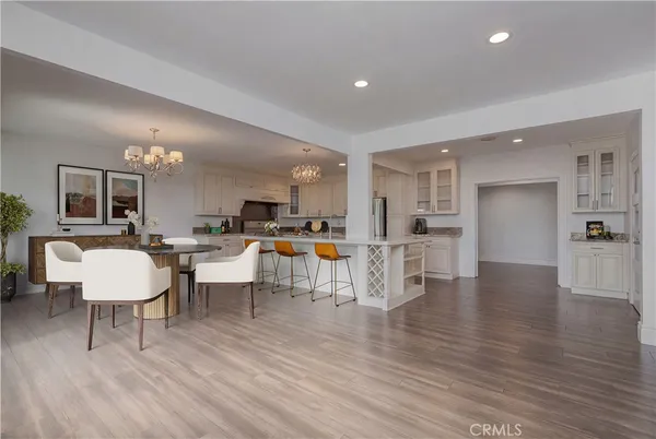 a living room with furniture and a dining table with wooden floor