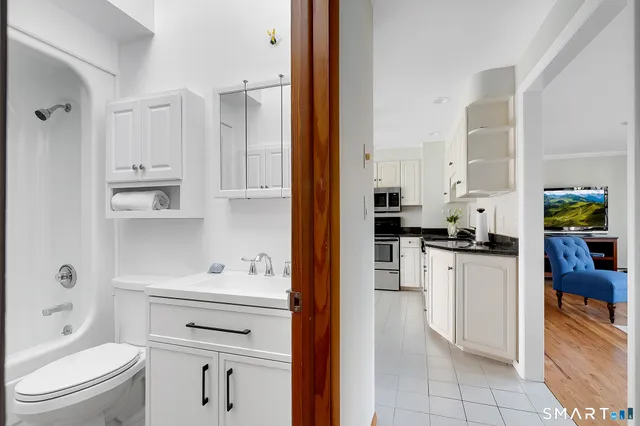 a kitchen with white cabinets and appliances