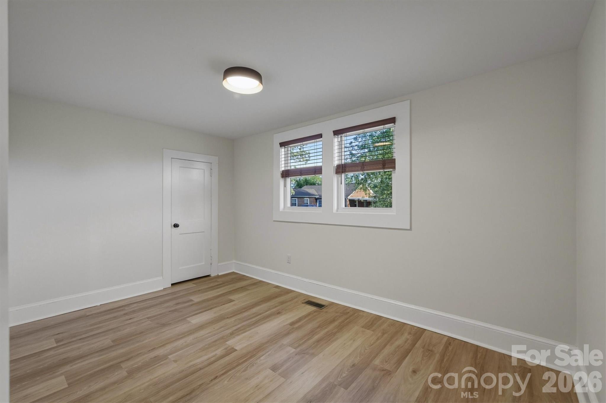 171 Duke Street Granite Falls, NC 28630 - Photo 12 of 15 an empty room with wooden floor and windows