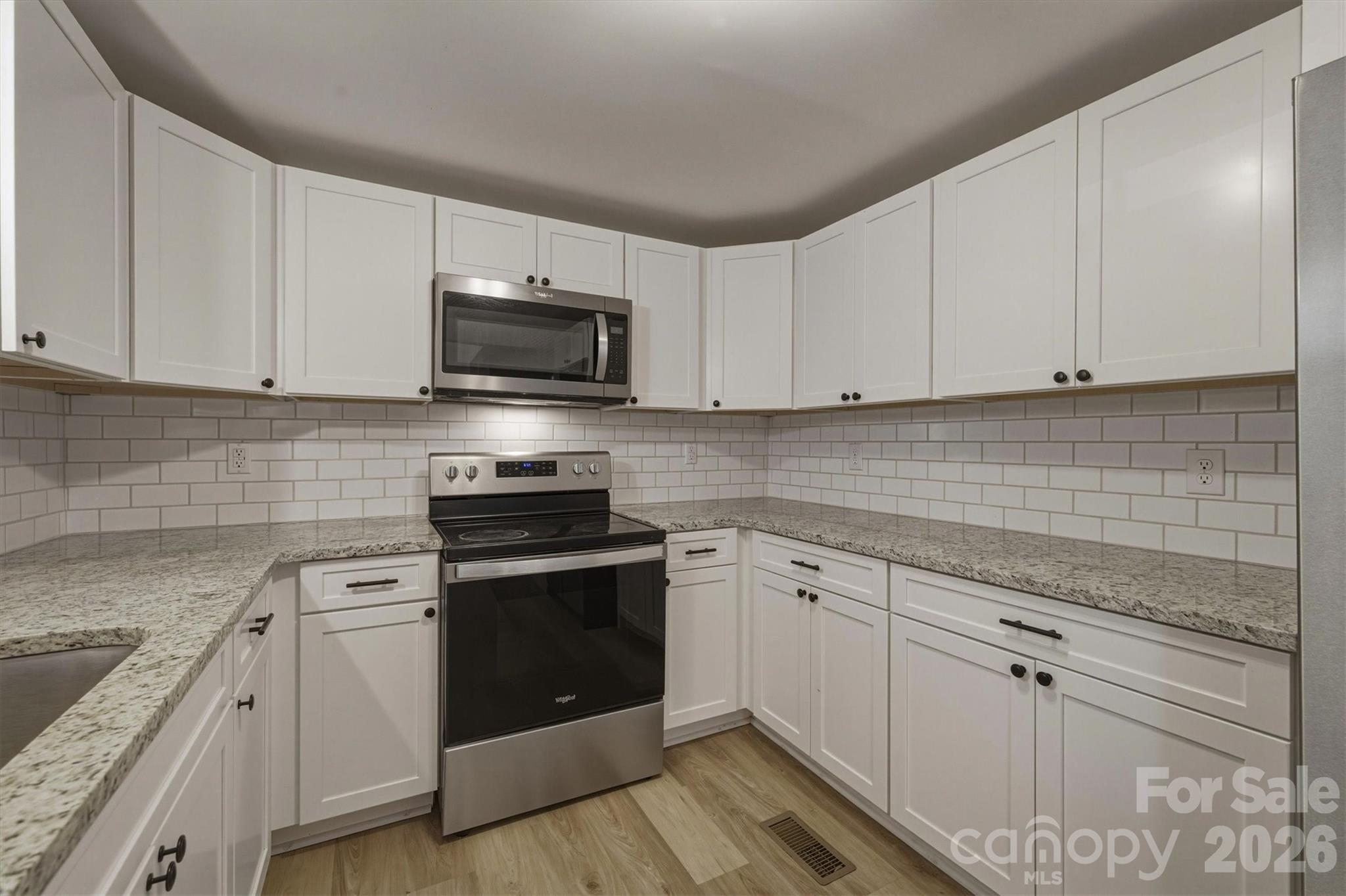 171 Duke Street Granite Falls, NC 28630 - Photo 8 of 15 a kitchen with white cabinets stainless steel appliances and sink