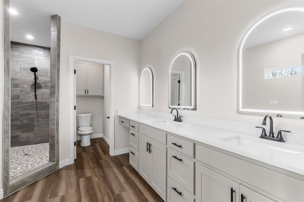4695 Sisk Road Wichita Falls, TX 76310 - Photo 20 of 32 Bathroom featuring wood-type flooring, toilet, vanity, and a tile shower