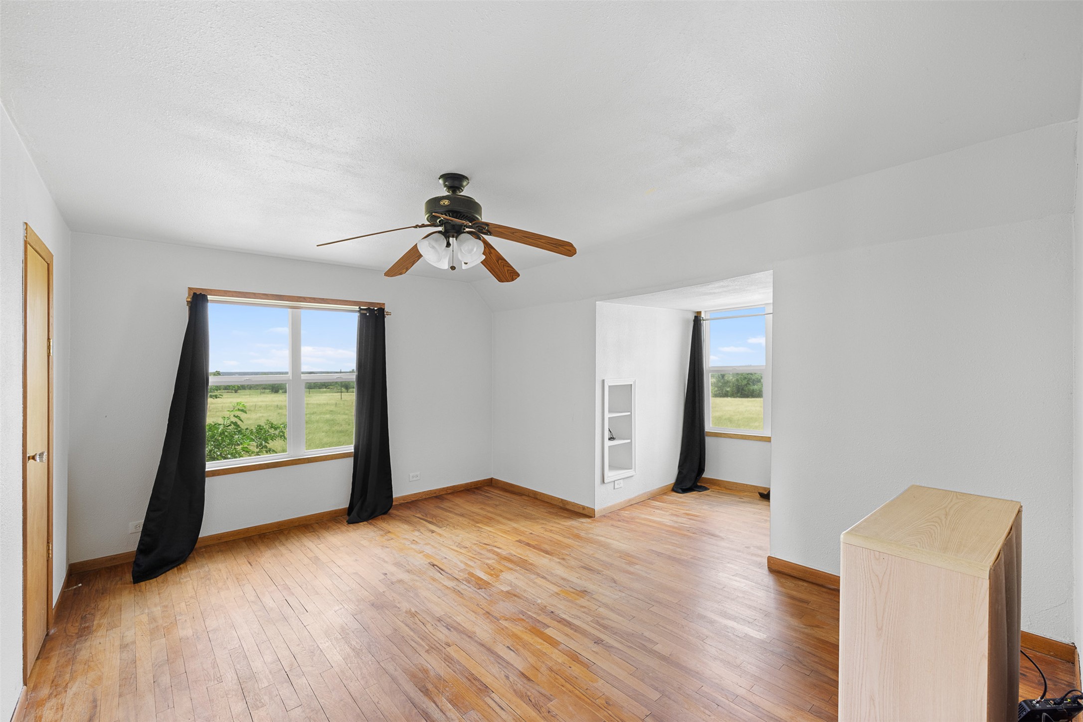 763 Upper Elgin River Road Elgin, TX 78621 - Photo 4 of 40 Hardwood floors and an airy ceiling fan create a comfortable atmosphere for relaxation.