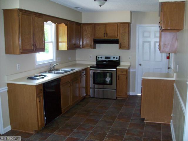 532 Apple Ridge Road Greensboro, NC 27406 - Photo 3 of 8 Kitchen. New flooring, cabinet hardware, sink/faucet, stainless/black appliances, paint.