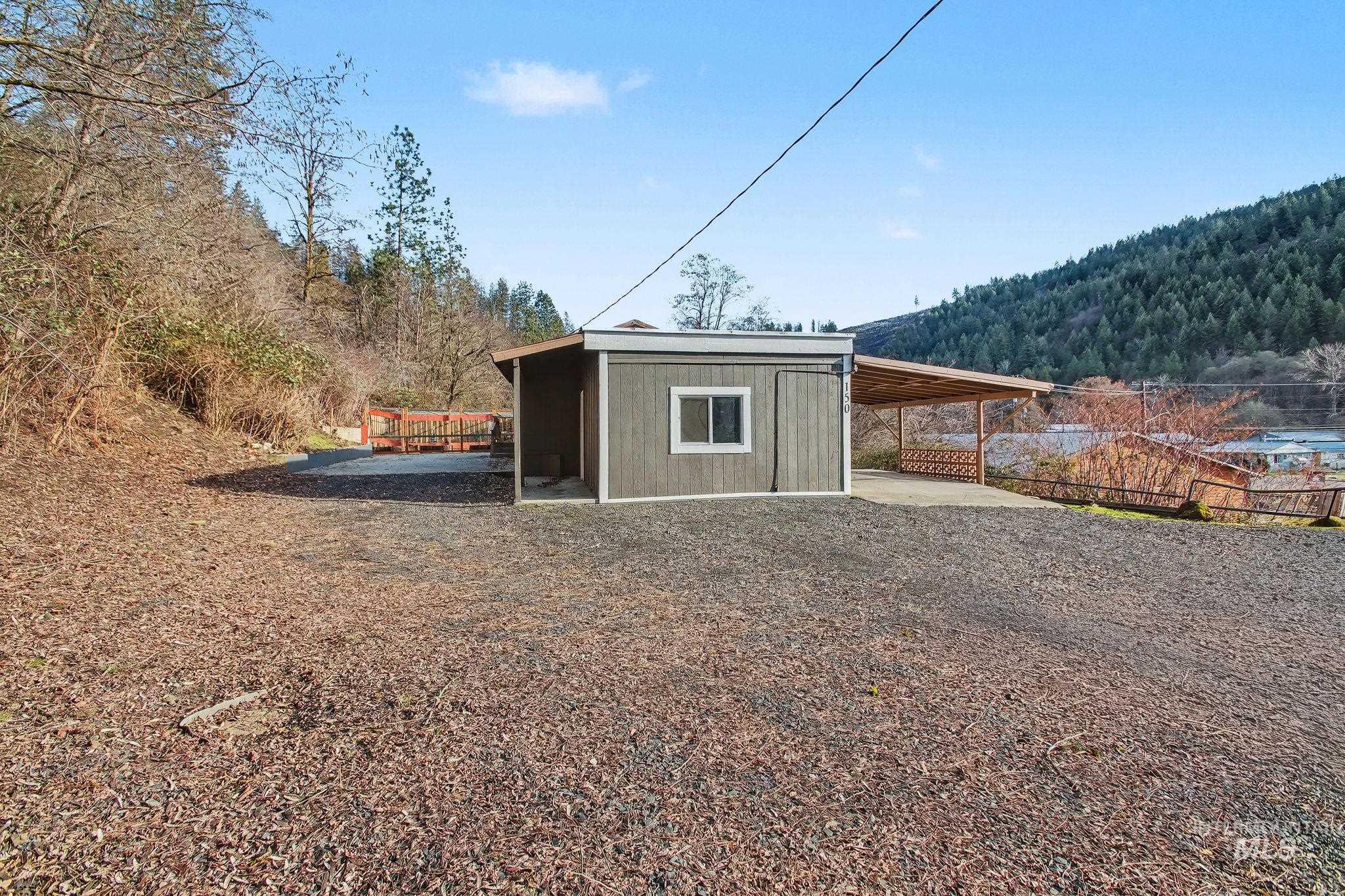 150 Elm Street Orofino, ID 83544 - Photo 26 of 36 Detached utility building featuring vertical siding, a single window, and an attached carport