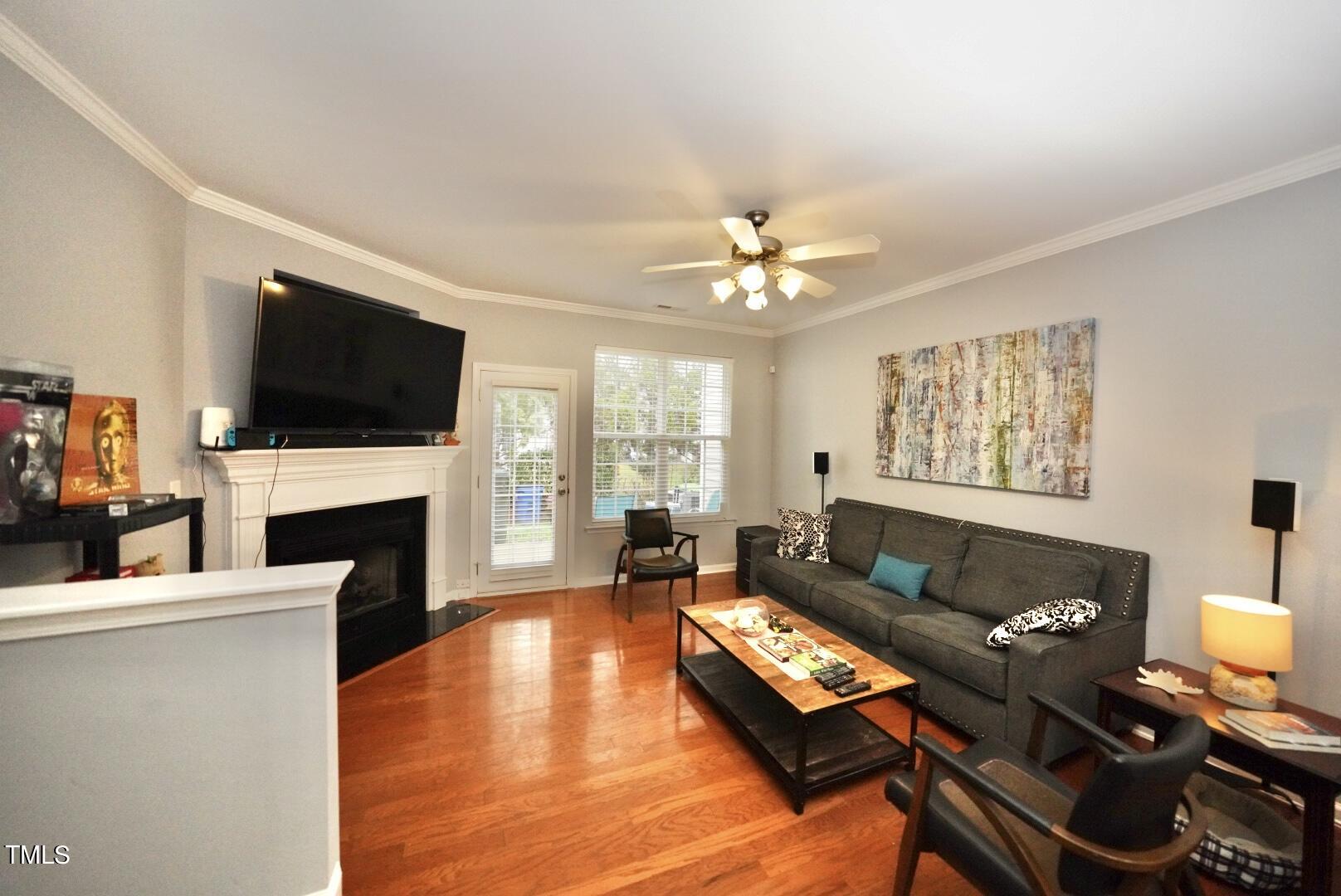 7815 Silverthread Lane Raleigh, NC 27617 - Photo 12 of 32 a living room with furniture a fireplace and a flat screen tv