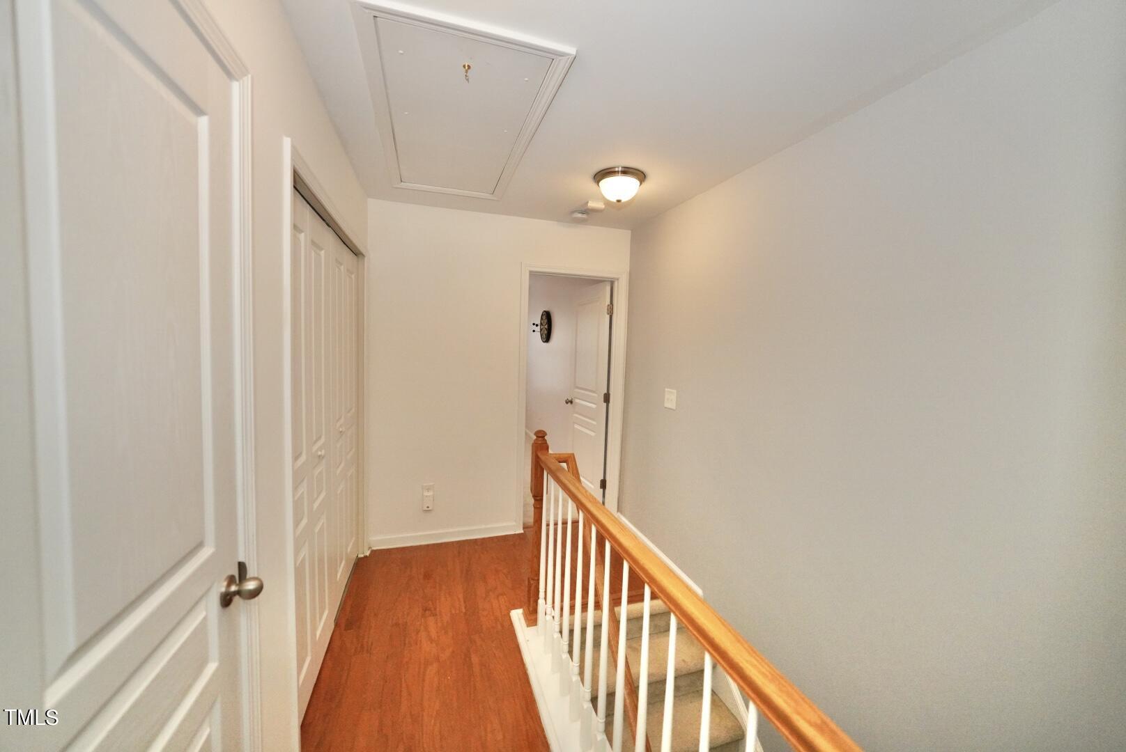 7815 Silverthread Lane Raleigh, NC 27617 - Photo 20 of 32 a view of a hallway with wooden floor and staircase