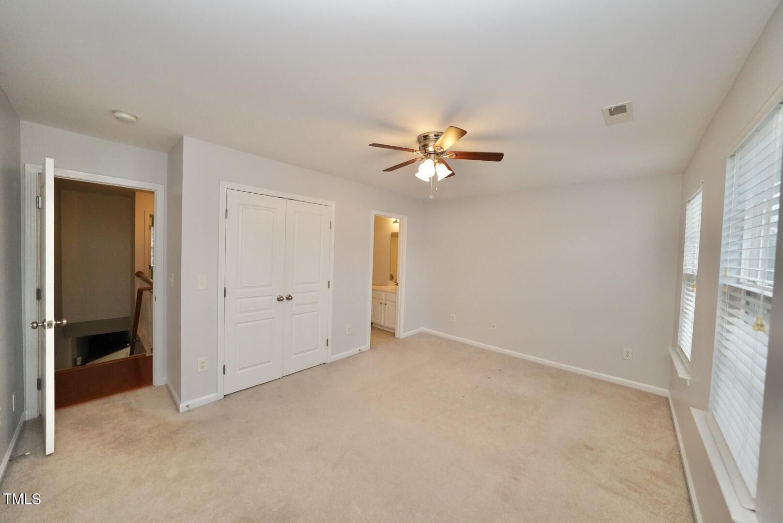 7815 Silverthread Lane Raleigh, NC 27617 - Photo 22 of 32 an empty room with a chandelier fan and a window