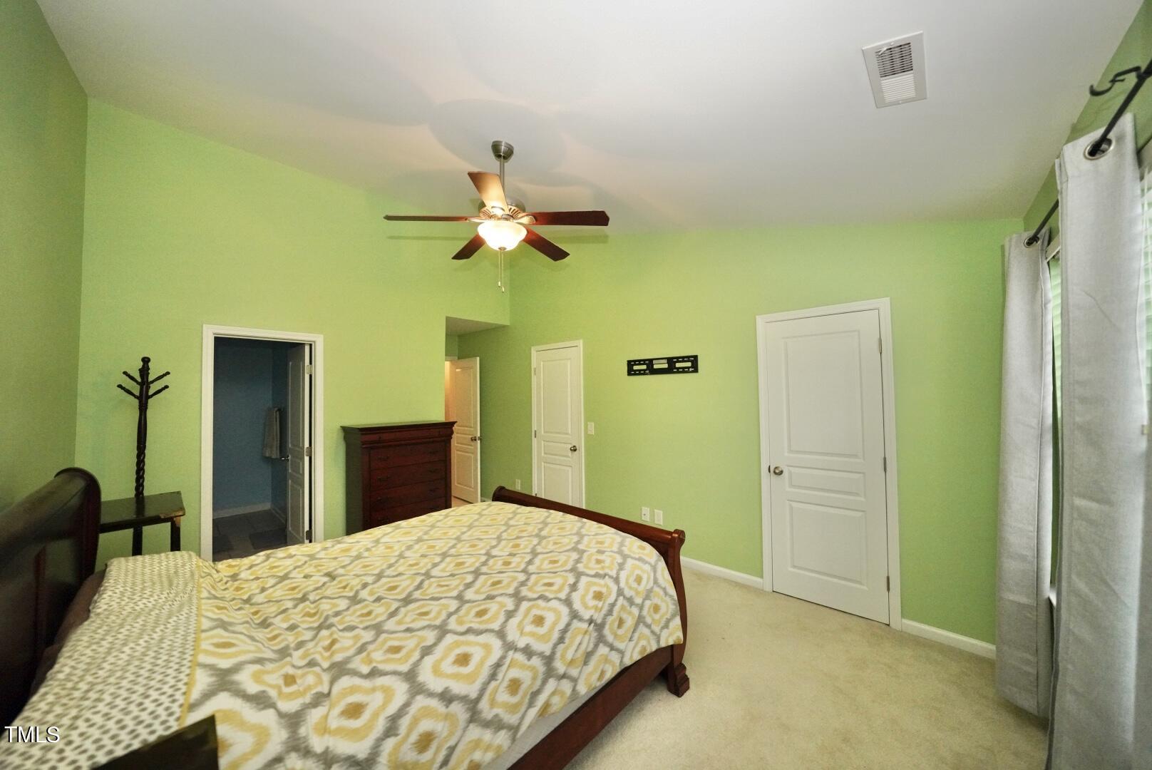 7815 Silverthread Lane Raleigh, NC 27617 - Photo 26 of 32 a bedroom with a bed and a chandelier