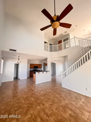 a view of a livingroom with a ceiling fan and kitchen view