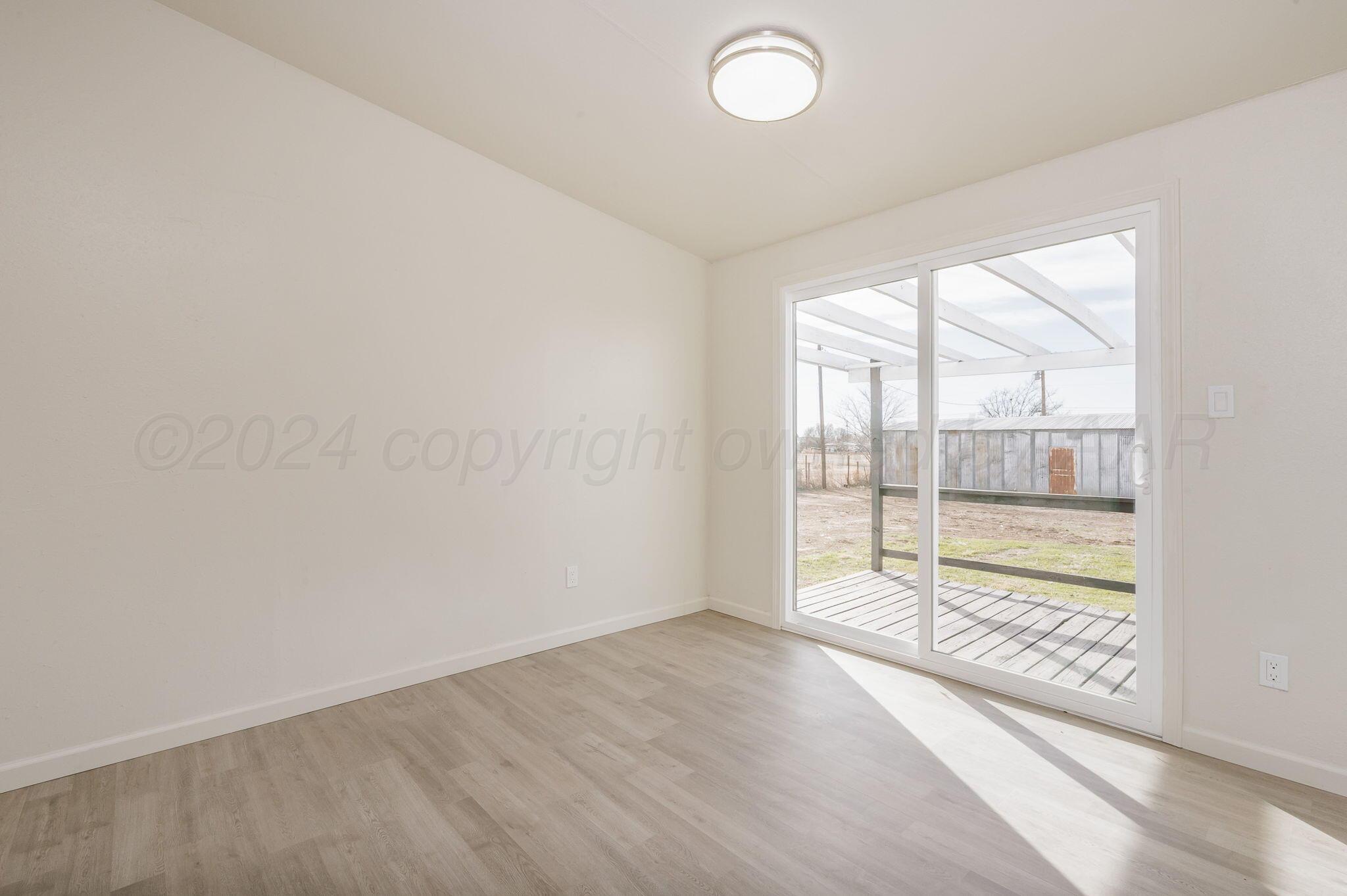 401 West Plantation Road Amarillo, TX 79118 - Photo 11 of 23 an empty room with wooden floor and windows