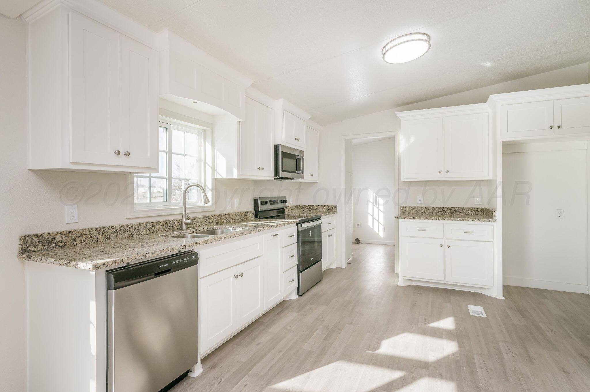 401 West Plantation Road Amarillo, TX 79118 - Photo 5 of 23 a kitchen with granite countertop white cabinets and white appliances