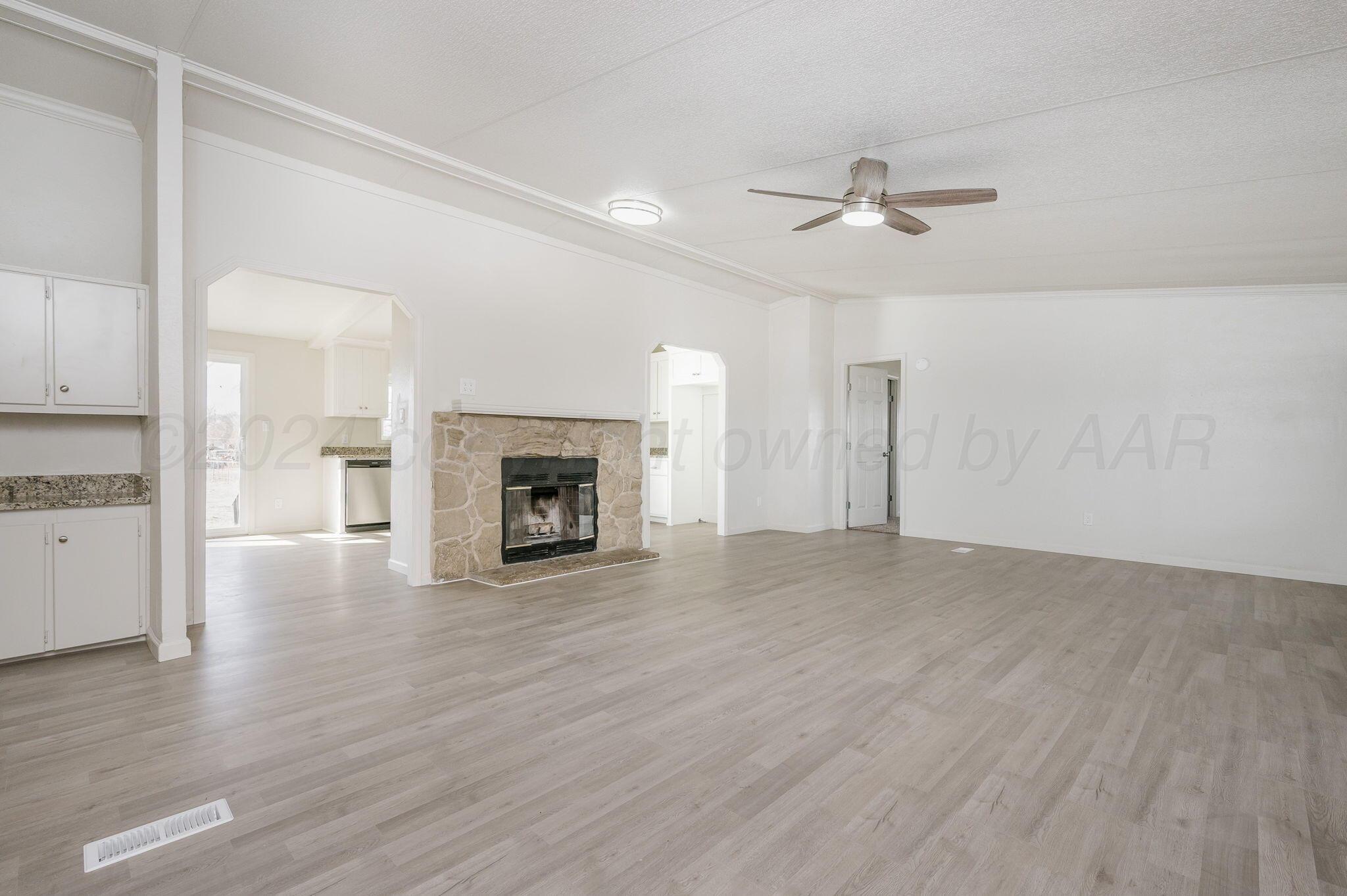 401 West Plantation Road Amarillo, TX 79118 - Photo 8 of 23 an empty room with wooden floor fireplace and windows