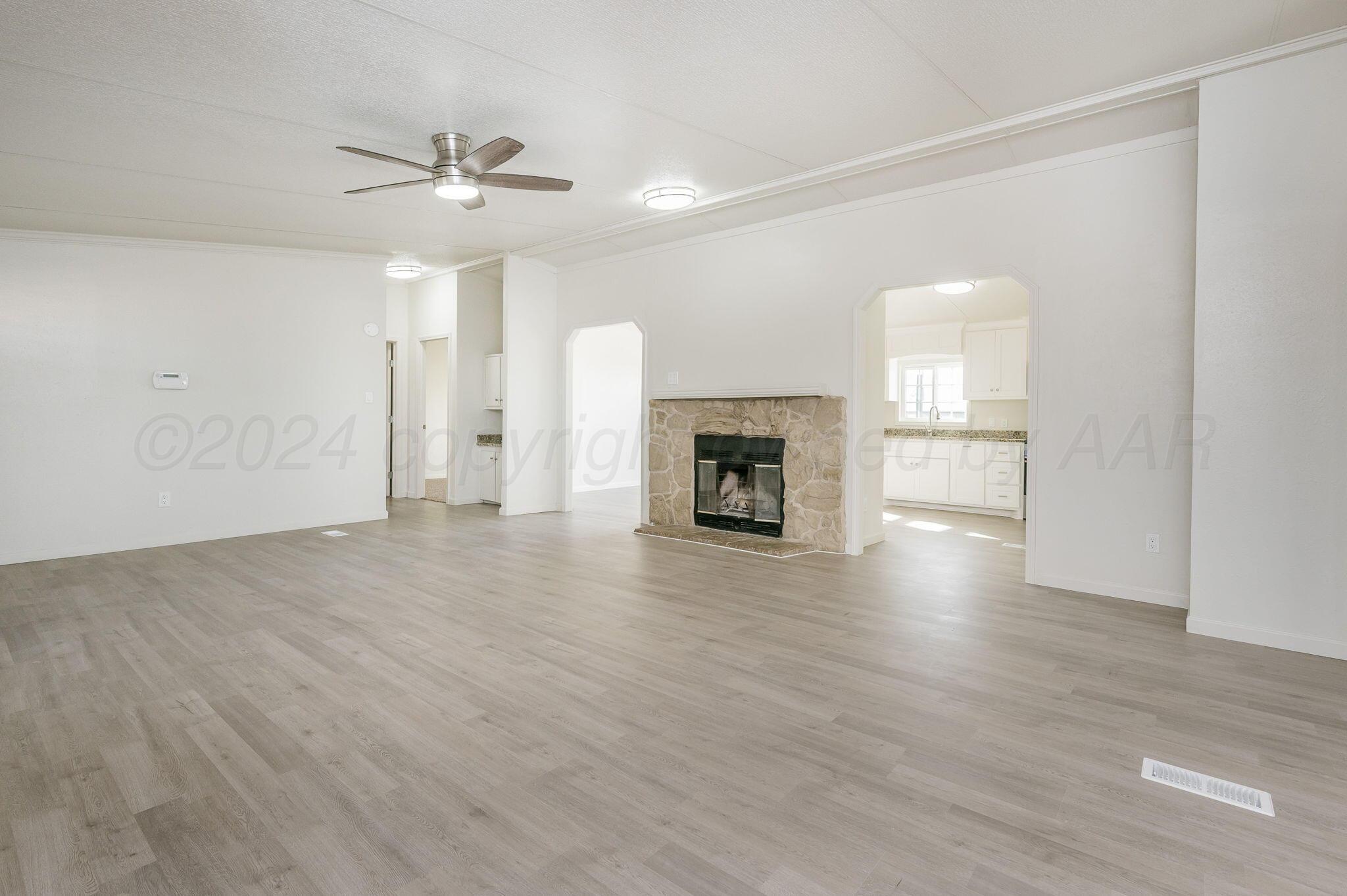 401 West Plantation Road Amarillo, TX 79118 - Photo 10 of 23 a view of empty room with a fireplace and wooden floor