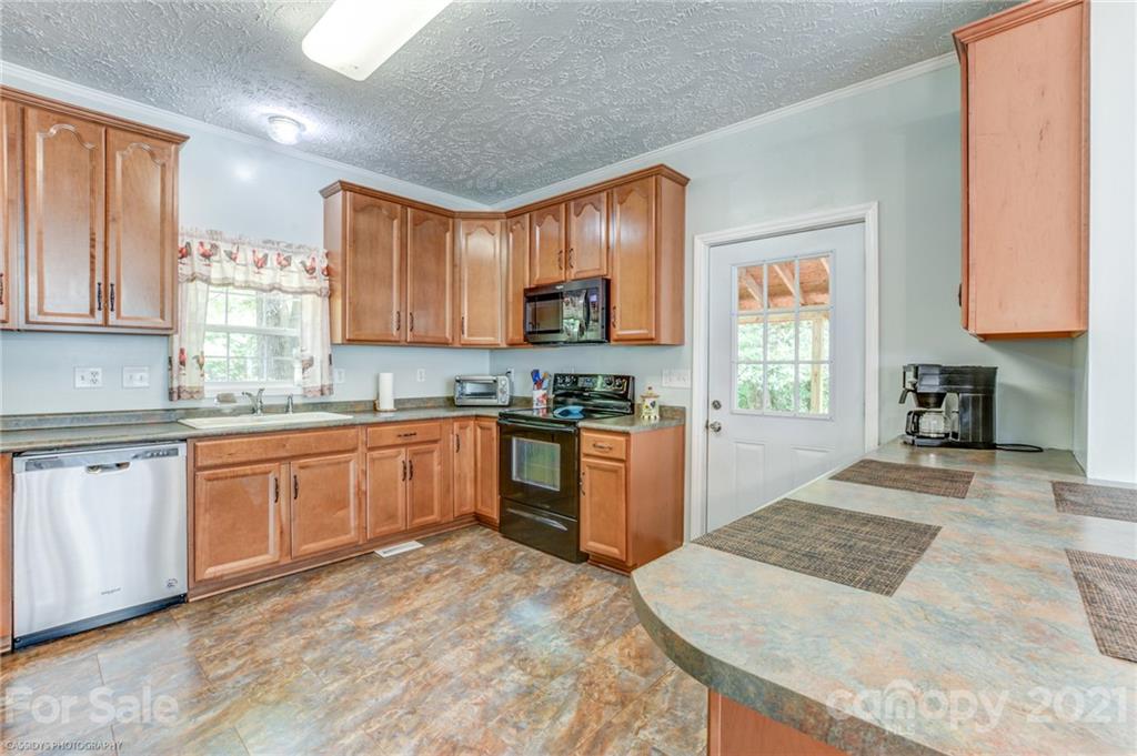 1968 Steel Hill Road Lancaster, SC 29720 - Photo 16 of 28 a kitchen with granite countertop a stove a sink and a refrigerator