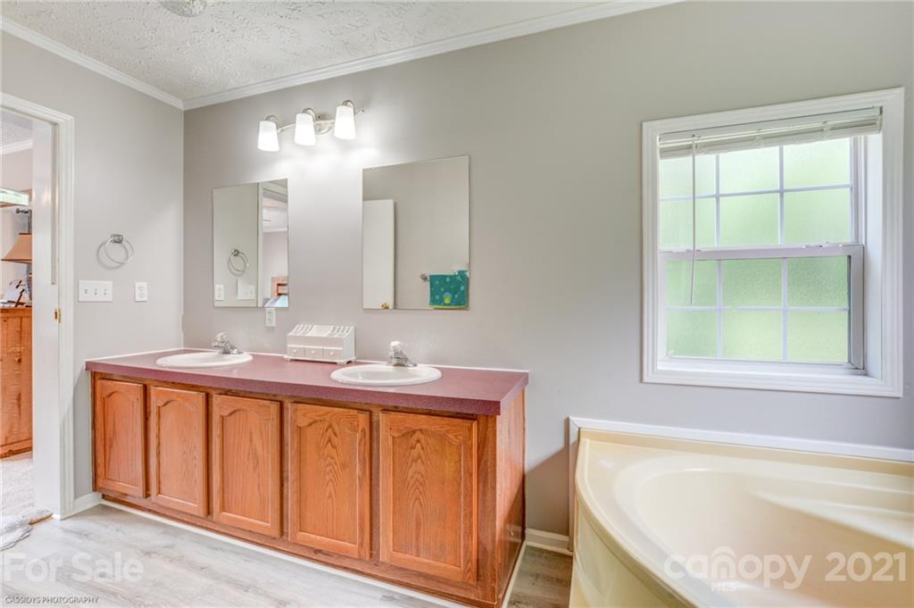 1968 Steel Hill Road Lancaster, SC 29720 - Photo 26 of 28 a bathroom with a granite countertop sink and a bathtub