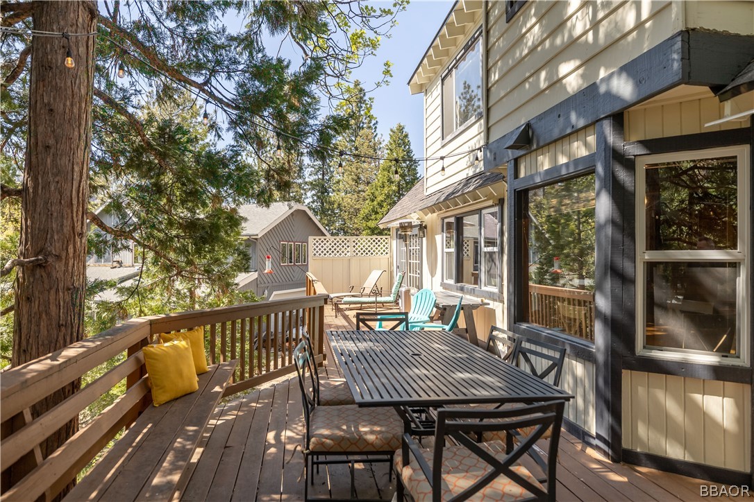 841 Golf Course Road Lake Arrowhead, CA 92352 - Photo 29 of 43 a view of a patio with table and chairs with wooden floor and fence