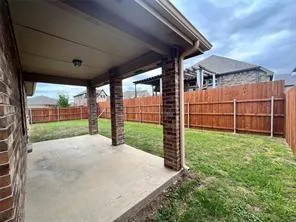 a view of a backyard with wooden floor and fence