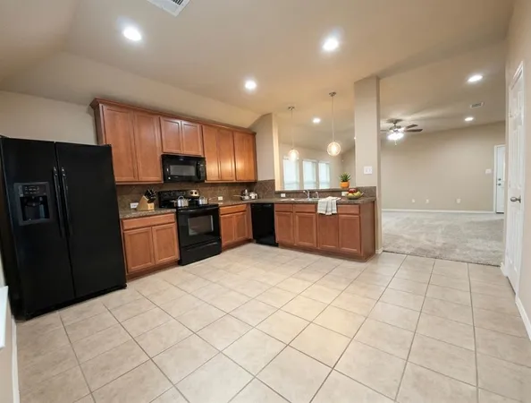 a kitchen with stainless steel appliances granite countertop a refrigerator and a sink