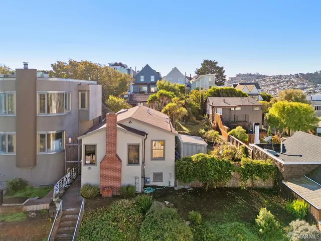 a view of a house with a big yard plants and large trees