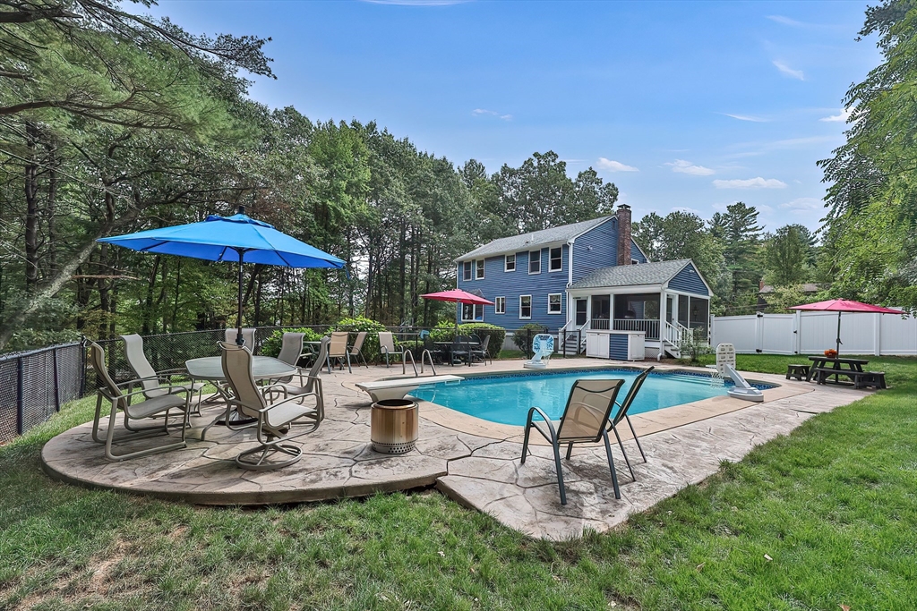 11 Puddingstone Lane Medway, MA 02053 - Photo 38 of 40 a patio with a table and chairs under an umbrella