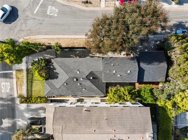 an aerial view of a house with a yard and large tree