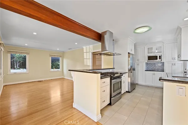 a kitchen with stainless steel appliances granite countertop a refrigerator and a stove top oven