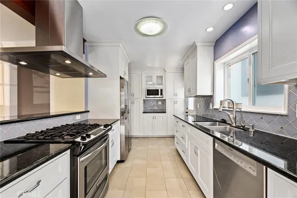 a kitchen with stainless steel appliances a sink stove and cabinets
