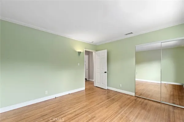 a view of empty room with wooden floor