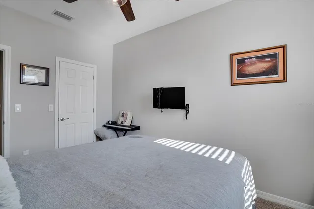 a bedroom with bed and a flat screen tv