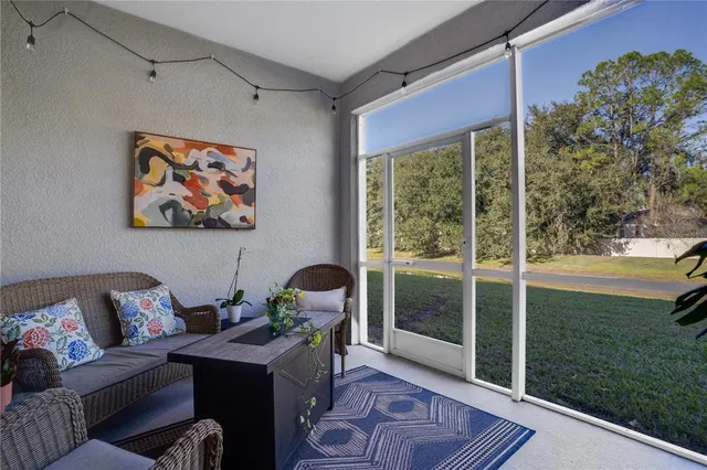 a living room with furniture and a floor to ceiling window