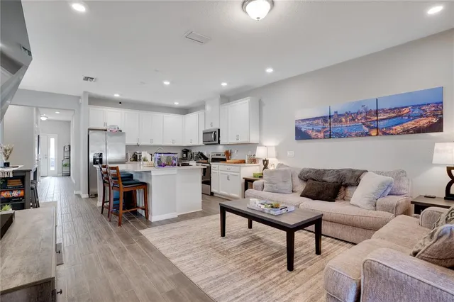 a living room with furniture and kitchen view