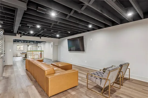 a living room with stainless steel appliances kitchen island granite countertop a stove and a wooden floors
