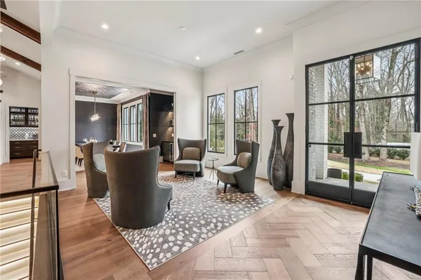 a living room with furniture a large window and wooden floor