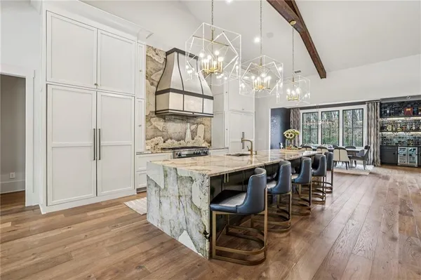 a kitchen with stainless steel appliances granite countertop a table chairs and wooden floor