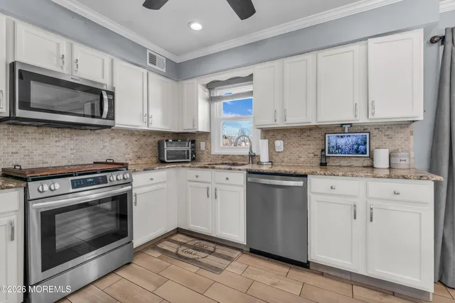 a kitchen with white cabinets stainless steel appliances and sink