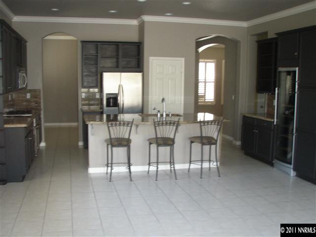 1794 Kodiak Circle Reno, NV 89511 - Photo 2 of 13 a dining hall with stainless steel appliances kitchen island granite countertop a refrigerator and cabinets